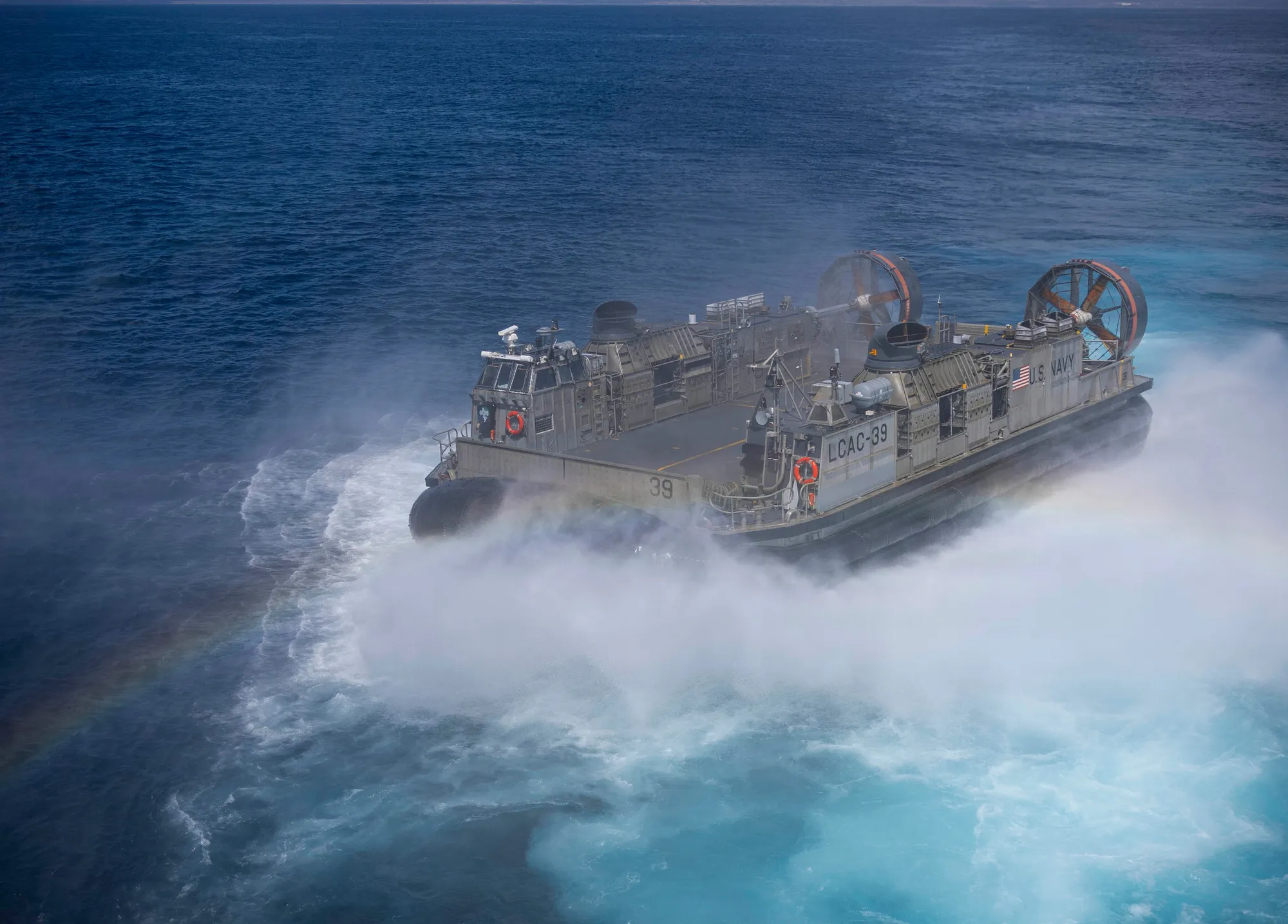 A Landing Craft, Air Cushion leaving the well deck of USS Makin Island in a cloud of spray